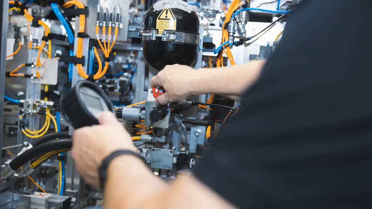 Mann überprüft Maschine mit Messgerät