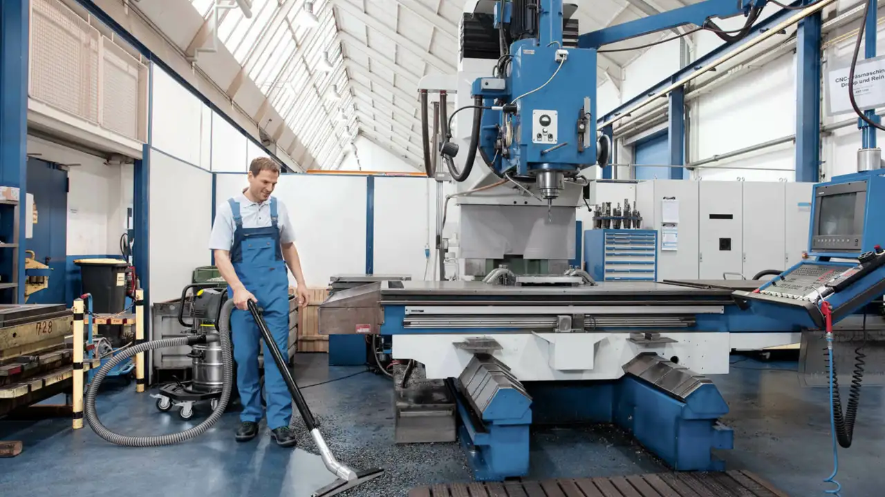 Person reinigt Boden in Industriehalle mit Kaercher Professional Industriesauger